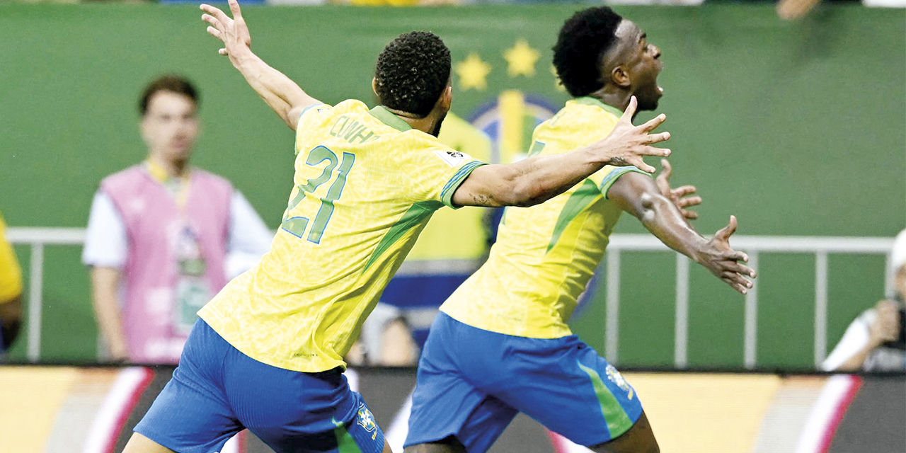 Vinicius (adelante) y Matheus Cunha festejan la sufrida victoria brasileña.