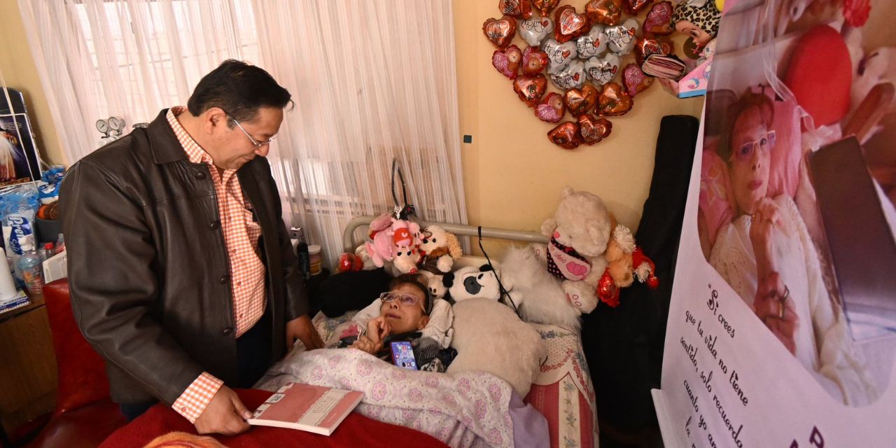 El presidente Luis Arce muestra el libro de Fabiola del Carmen Maldonado Bascopé.
